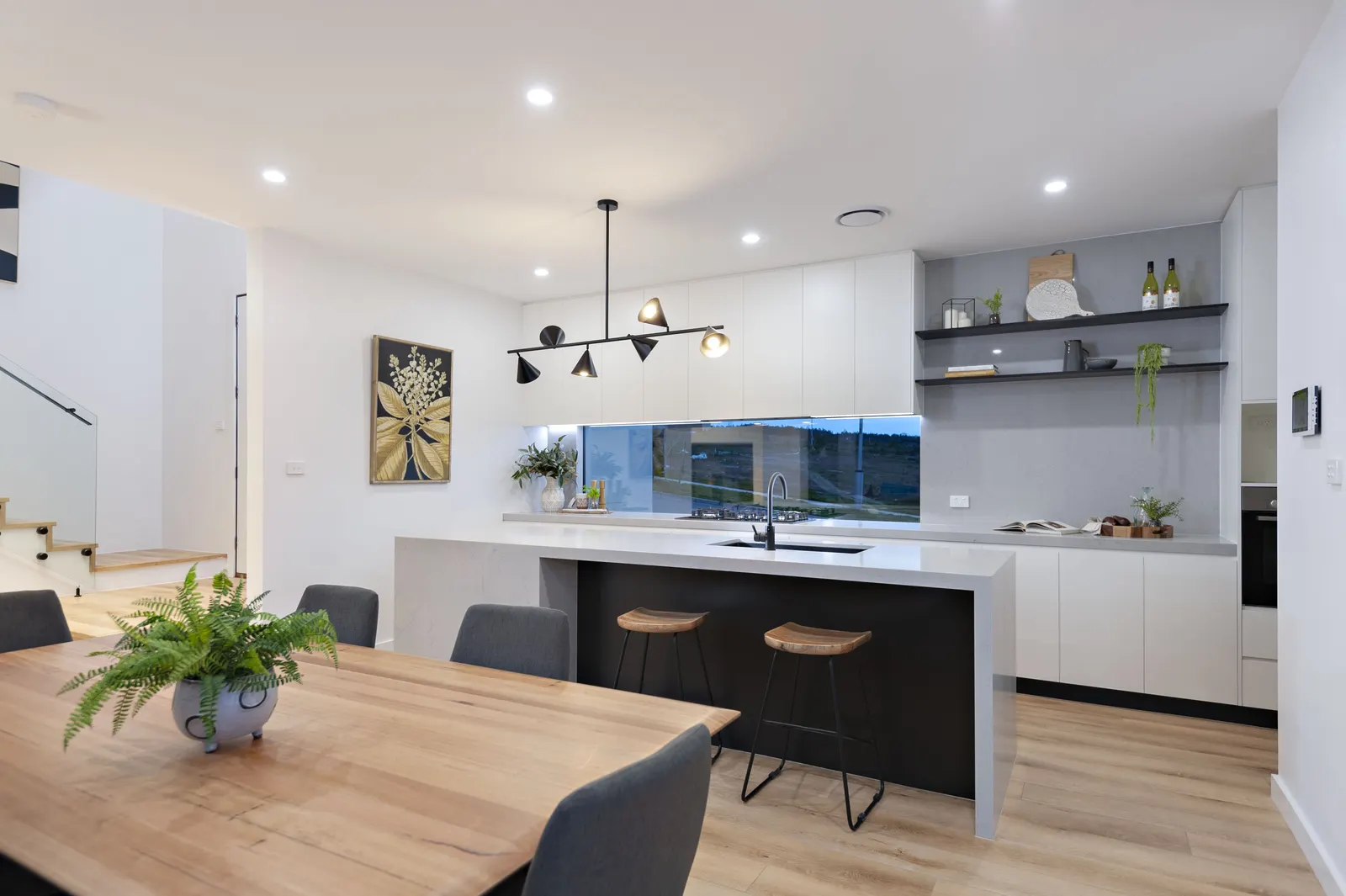 Kitchen with window splashback, stone island and black tapware