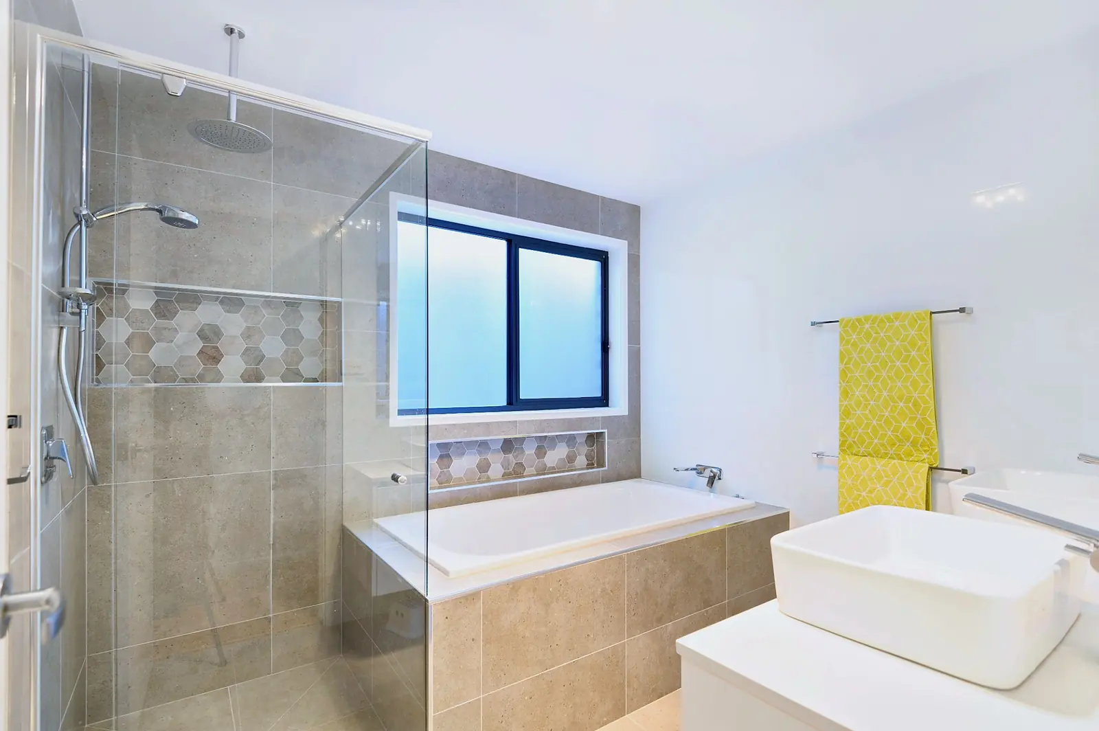 Bathroom with inset bath, frameless glass shower and feature tiled niche