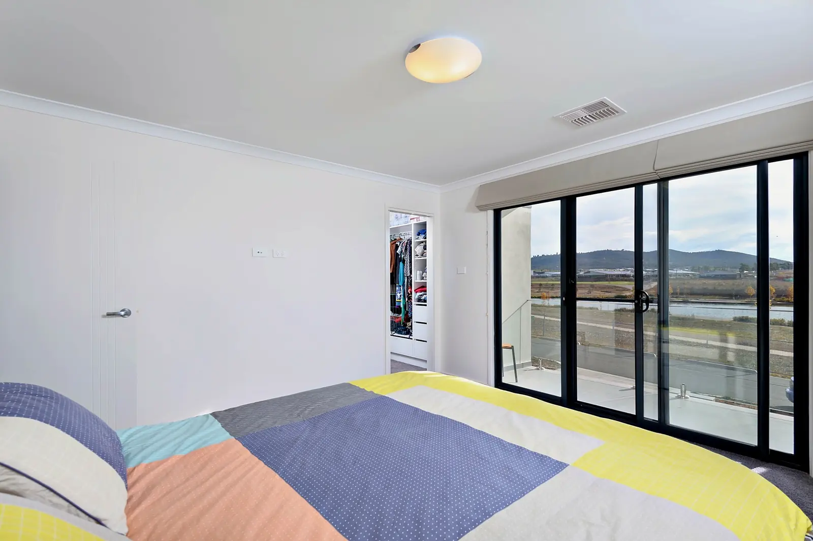 Main bedroom with walk in robe and sliding doors to the balcony