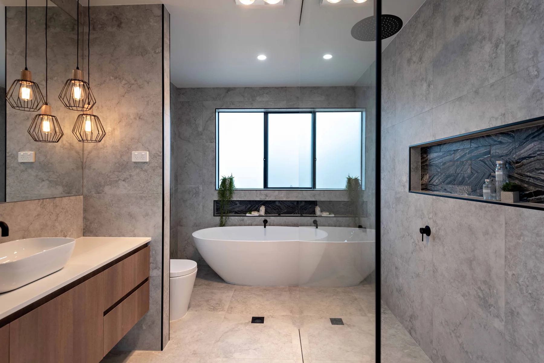 Main bathroom with freestanding bath, dual showers and feature tiled niche