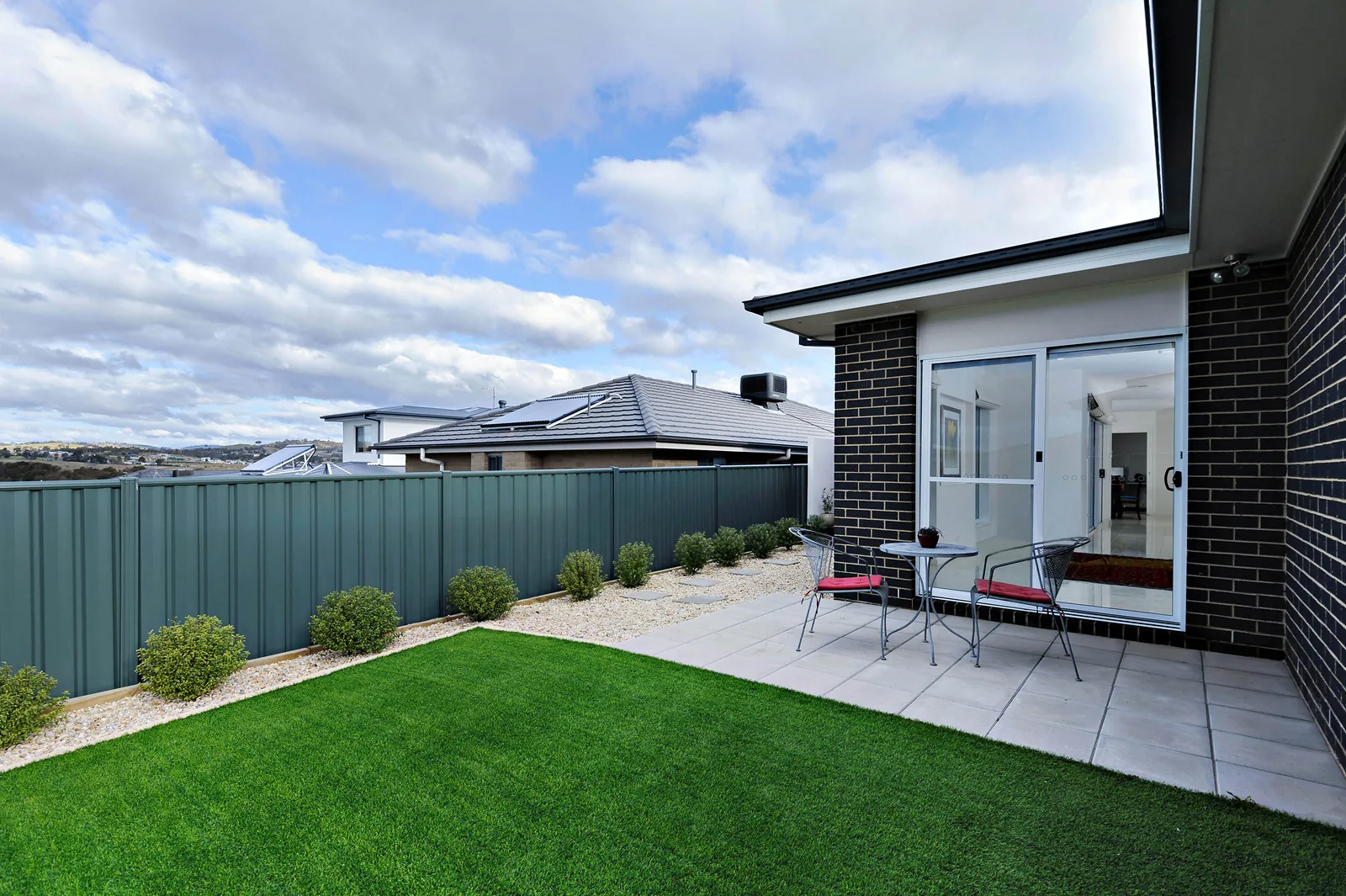 Landscaped backyard with paved entertaining area, easy care lawn and valley outlook