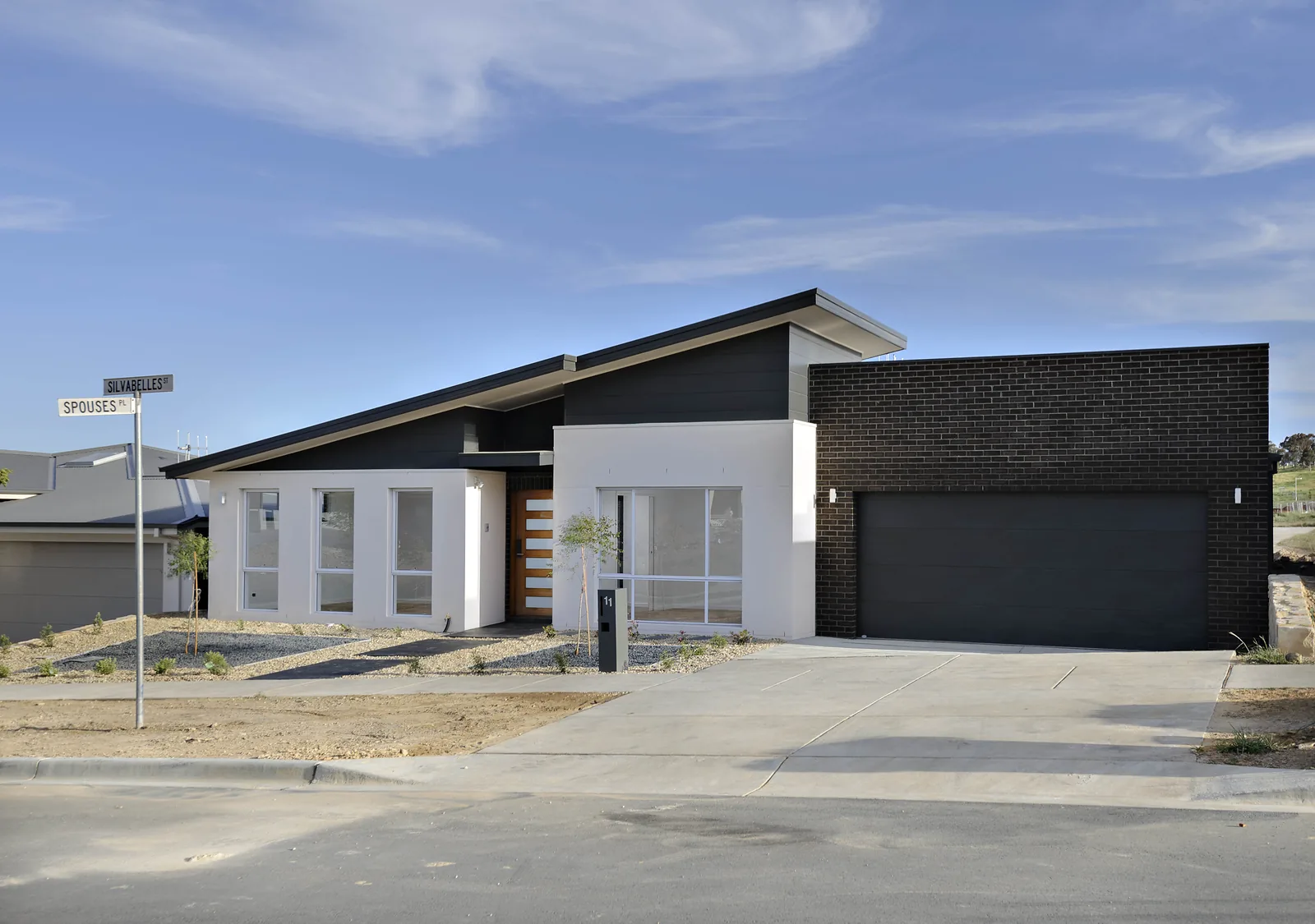 Completed new home with skillion roof and dark brick garage, Moncrieff ACT