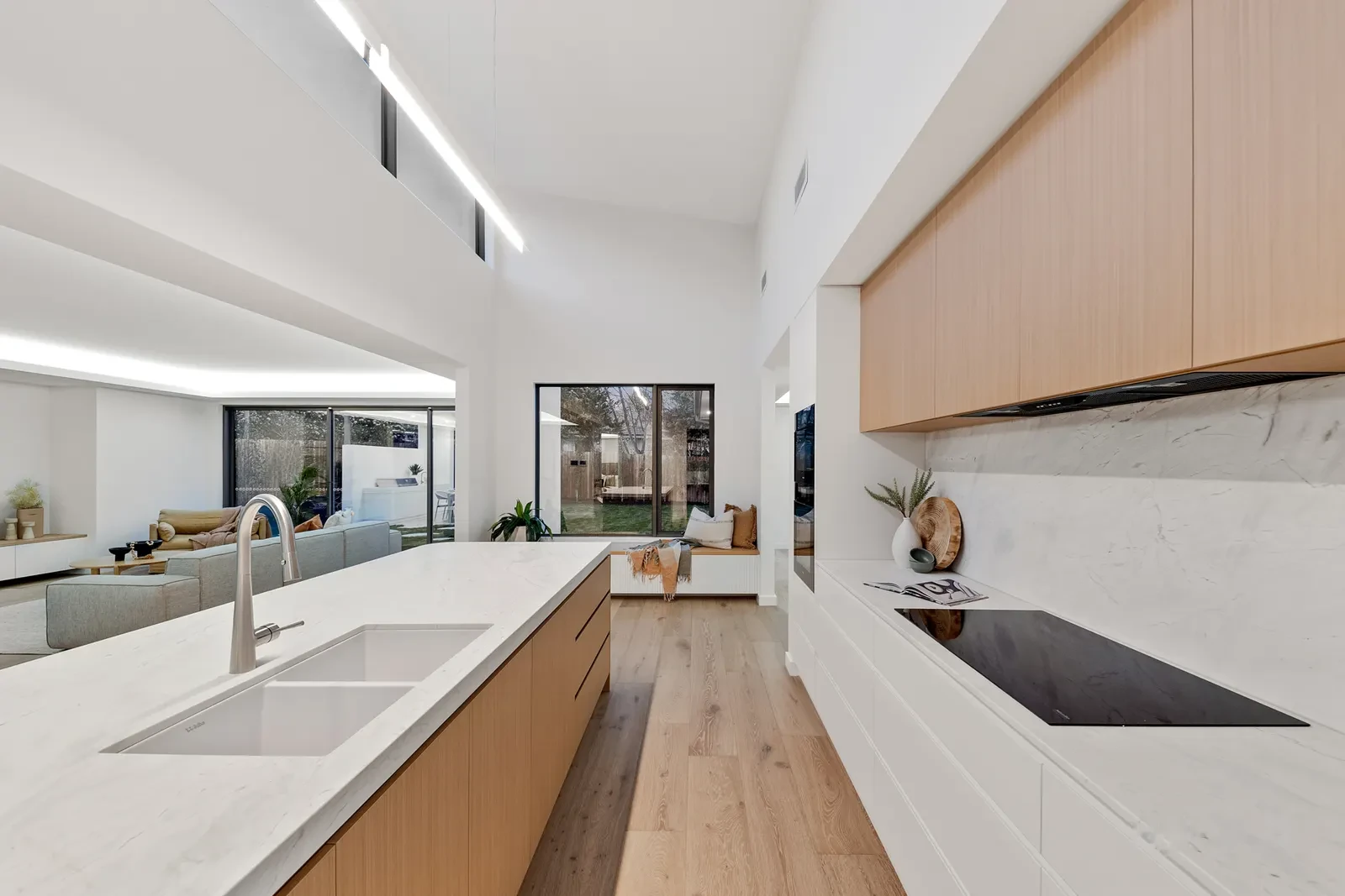 Kitchen with curved stone island bench and timber overhead canopy