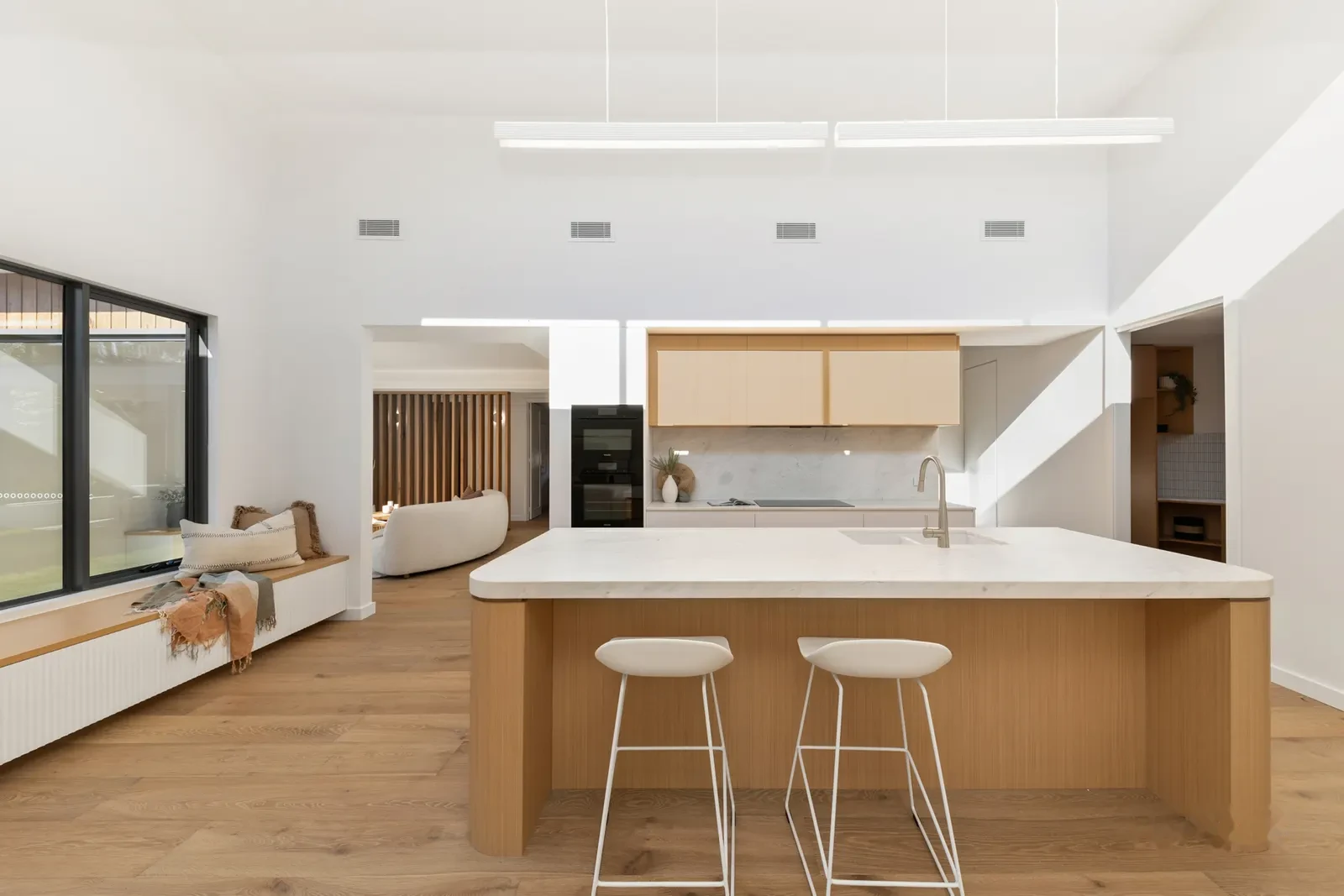Kitchen with stone island and skylight slot washing the ceiling in daylight
