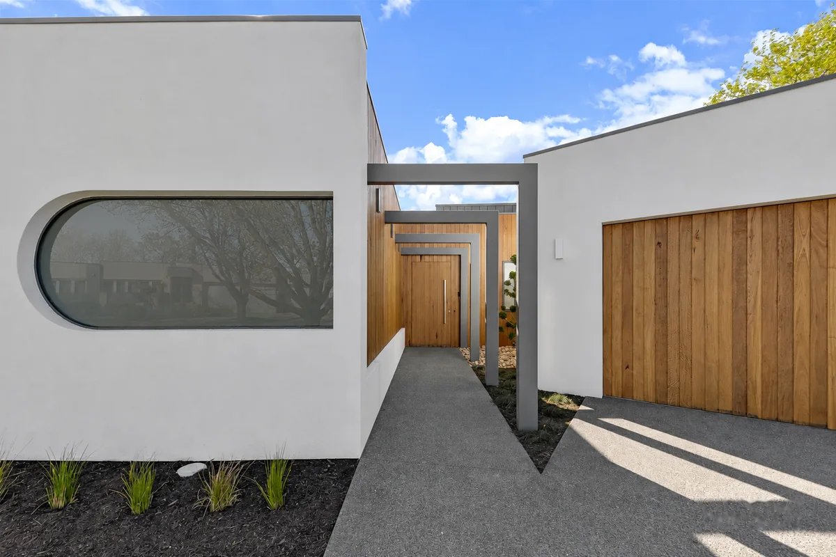 Porthole window in the curved render beside the timber lined entry passage